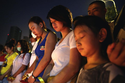 Citizens mourn for the victims of the warehouse explosions at a temporary shelter in Tianjin, north China, Aug. 13, 2015. The death toll from warehouse explosions in north China's Tianjin city rose to 50 Thursday evening. (Xinhua/Cai Yang)