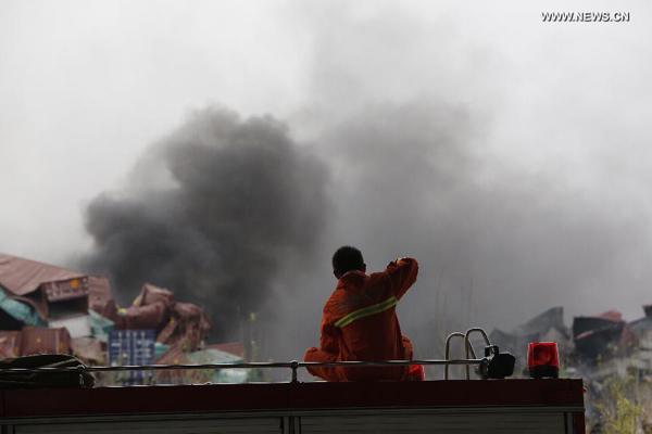 Firefighters put out a big fire point at the explosion site in Tianjin, north China, Aug. 14, 2015. The death toll has risen to 56, including 21 firemen, 721 others were hospitalized, including 25 critically wounded and 33 in serious condition, the rescue headquarters said Friday. (Xinhua/Shen Bohan)