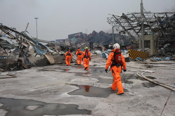 Firefighters wearing chemical protective clothing work in the core area of explosion site in Tianjin, north China, Aug. 15, 2015.  (Photo： Xinhua/Jin Liwang)