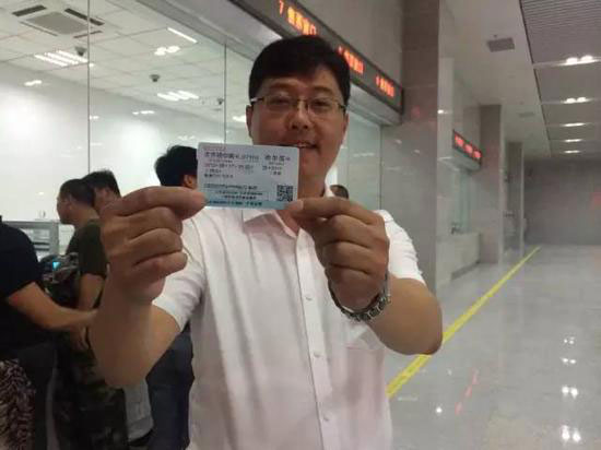 A passenger shows his ticket for the D5001 high-speed train in Qiqihaer City, capital of northeast China's Heilongjiang Province, August 16, 2015. (Photo/hexun.com)