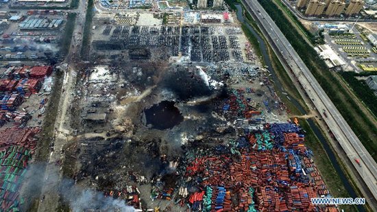 An aerial photo taken on Aug. 14, 2015 shows a huge hole at the core area of explosion site in Tianjin, north China. The death toll from explosions occurred on Wednesday night rises to 85 as of Saturday mornoing. (Photo/Xinhua)