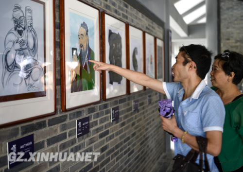 Visitors look at cartoons of Confucius on Aug. 15. (Photo: Xinhua/Liu Xu)
