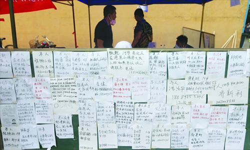 A message board is erected on Saturday in a temporary settlement camp in a local primary school in Tianjin where families of the missing have posted notices to search for their loved ones. (Photo: Cui Meng/GT)