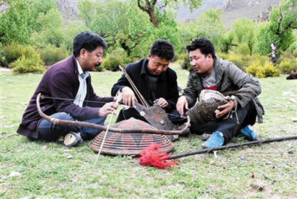 Chojor, center, explains the background of some ancient weapons to friends. (Photo/chinatibetnews)