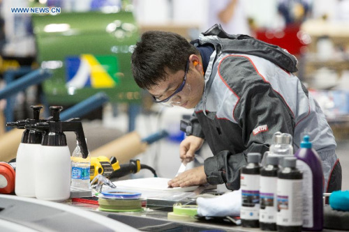 Yang Jinlong, competitor from China, participates in the competition of Car Painting in Sao Paulo, Brazil, on Aug. 13, 2015. Yang Jinlong won the gold in the competition. The 43rd Worldskills Competition concluded here on Sunday. (Photo: Xinhua/Xu Zijian)