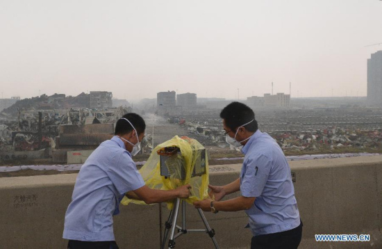 Workers cover a rain hood for a detector near the explosion site in Tianjin, north China, Aug. 18, 2015. A rainfall began to hit the city on Tuesday. (Photo: Xinhua/Wang Qingqin)