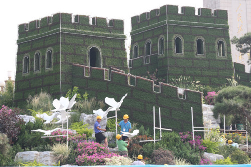 Construction workers are building a Great Wall-themed flower terrace in Tian'anmen Square in Beijing to prepare for the military parade that marks the 70th anniversary of victory in World War II. (China Daily/Wang Zhuangfei)