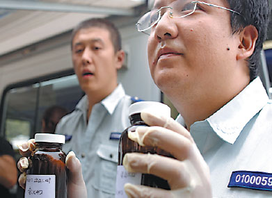 Experts from Beijing Environmental Monitering Center display the tested samples collected from the blast zone in Tianjin on Tuesday. Zhu Xingxin / China Daily