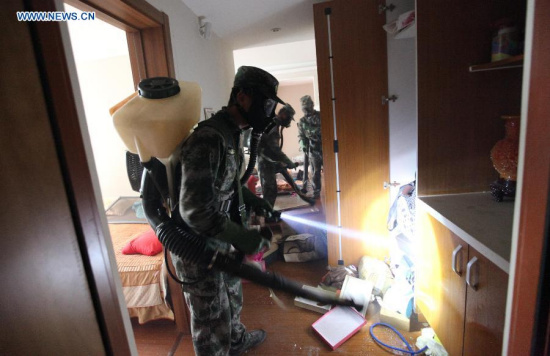 Military specialists in handling nuclear and biochemical materials decontaminate at a residential community near the core area of the warehouse explosion site in Tianjin, north China, Aug. 18, 2015. (Xinhua/Wang Haobo)