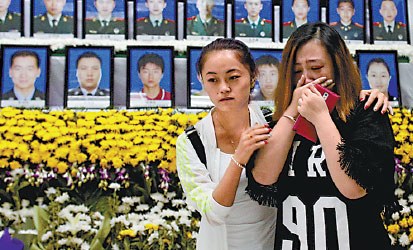 At the memorial hall of the fire department in the Tianjin Binhai New Area, residents pay respect on Tuesday to the firefighters who died in last week's explosions.  (Zhu Xingxin/China Daily)