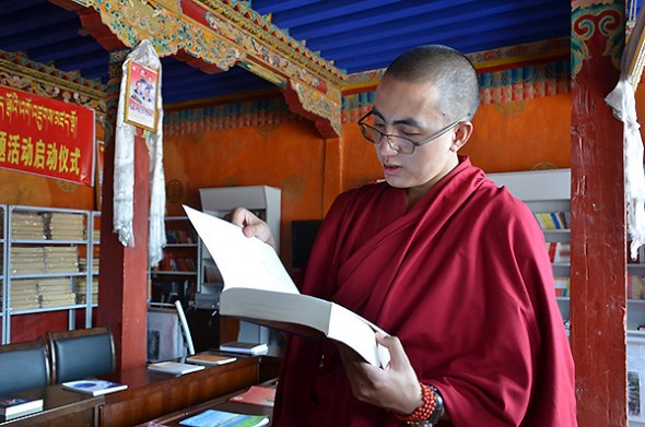 Tenzin Yontan, a Tibetan Buddhist monk, reads a book at the Champa Ling Monastery in Qamdo, a city in the east of the Tibet autonomous region, Aug 7, 2015. (Photo: chinadaily.com.cn/Chen Bei) 