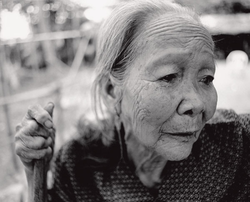 Zheng Jinnyu sheds tears while recalling the past at her home in Nongqing village, Lingshui county, Hainan province, in 2005. She was born in 1926 and passed away in 2006. She was raped by three Japanese soldiers while working in the fields when she was 16, and later forced to become a comfort woman. (China Daily/Huang Yiming)