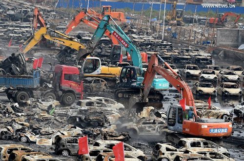 Rescuers and machines clean up burnt vehicles in the core blast area in Tianjin, north China, Aug. 20, 2015. (Photo: Xinhua/Zhang Chenlin)