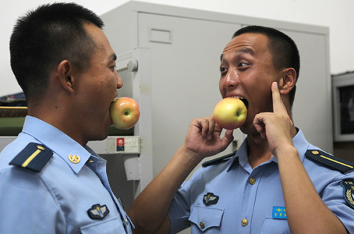 Sun Jingfeng, right, a student from the PLA Air Force Engineering University, is a singer in the chorus. (Photo: China Daily/Zhou Hong)