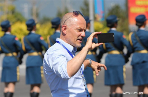 A reporter films with his cellphone at the parade training base in Beijing, Aug 22, 2015. More than 90 journalists of over 50 medias from home and abroad visited Beijing's parade training base where Chinese soldiers and military officers participate in training for the Sept 3 military parade in commemoration of the 70th anniversary of the end of WWII. [Photo/Xinhua]