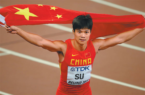 Chinese sprinter Su Bingtian embraces the national flag after finishing ninth in the men's 100m final at the world championships on Sunday. (Xu Jingxing/China Daily)
