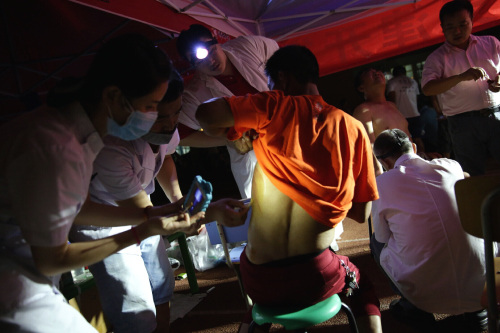 Doctors tend to the wounded in a makeshift clinic located within the No. 2 Elementary School of the Binhai New District Development Zone in Tianjin on August 13 (XINHUA)