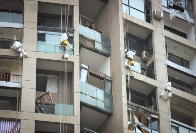Workers clean windows at the residential building called Jinyulanwan in Tianjin after the Aug 12 massive blasts. (Photo/Xinhua)