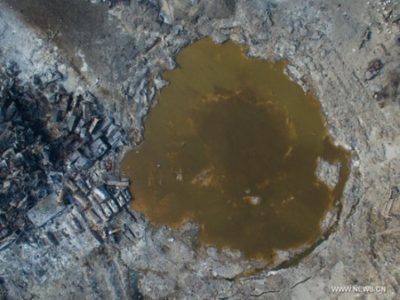 Photo taken on Aug. 26, 2015 shows a waste water pool at the core area of explosion site in Tianjin, north China. (Photo: Xinhua/Guo Yu)