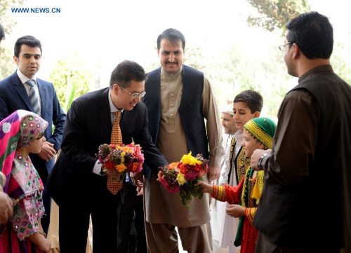 Chinese Ambassador to Afghanistan Deng Xijun (3rd L) receives flowers from Afghan children in Kandahar province in southern Afghanistan, Aug. 30, 2015. (Xinhua/Sanaullah)