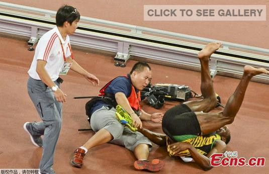 Usain Bolt (L) of Jamaica is knocked over by a cameraman on a Segway after the men's 200m final during the 15th IAAF World Championships at the National Stadium in Beijing August 27, 2015. (Photo/Agencies)