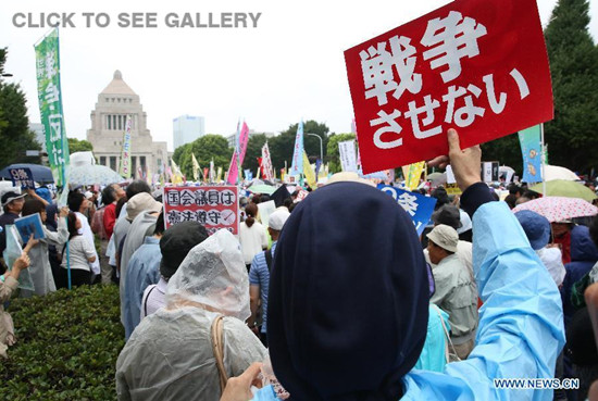 Protesters hold placards during a rally against the controversial security bills in Tokyo, Japan, Aug. 30, 2015. (Photo: Xinhua/Liu Tian)