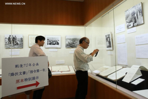 Visitors look at the original Instrument of Surrender of Japan's surrender to the Allied Forces in World War II, at an exhibition in Tokyo, Japan, Sept. 1, 2015. (Photo: Xinhua/Liu Tian)