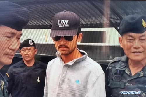 A TV screenshot taken on Sept. 1, 2015 shows Thai policemen escorting a suspect (C) in Bangkok, Thailand. Thai police on Tuesday morning arrested an important suspect of the recent deadly bombing attack at Erawan Shrine in downtown Bangkok, police spokesman Prawut Thawornsiri said. (Xinhua)