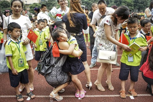 A first-grader hugs her mother on her first day at primary school in Chengdu, Sichuan province, on Tuesday. For Chinese parents, enrolling their children in a good public primary school is becoming increasingly difficult. (China Daily/He Haiyang)