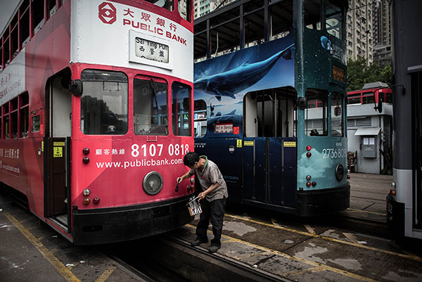 A worker repaints the bumper of a tram at a depot in Hong Kong on Aug 25. (Photo/Agencies)