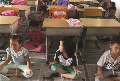 Pupils sit in meditation in a primary school classroom during mid-day break in Foshan, South China's Guangdong province. (Photo/Jiangnan Times)