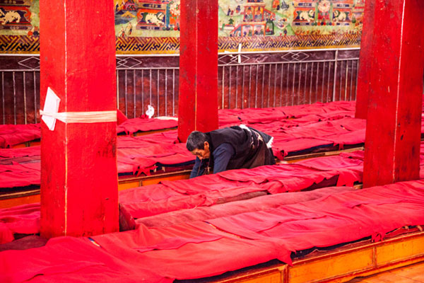 Tibetan Buddhist prays as he crawls from the monestery's entrance to the Buddha statue (not seen in this picture) and kowto, at Champa Ling Monastery. Photo by Yuan Yong/Provided to chinadaily.com.cn