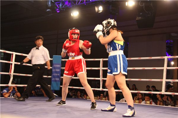 Laura Grant (in red), 25, of the UK fights against opponent Samantha Kwok, 24, of Australia, during the 2015 White Collar Boxing event at the Park Hyatt Hotel in Beijing on Sept 5. (Photo by Jiang Wanjuan/chinadaily.com.cn)