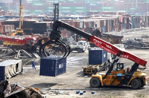 A crane moves away a destroyed container at the core area of an warehouse explosion in Tianjin, north China, Sept. 8, 2015. (Photo/Xinhua)