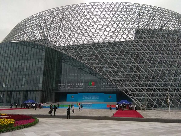 Guests and visitors walk in front of the Ningxia International Conference Center, which hosts the opening ceremony of the China-Arab States Expo in Yinchuan, the capital of Ningxia on Sept 10, 2015.(Photo by Wu Yanpeng/China Daily)