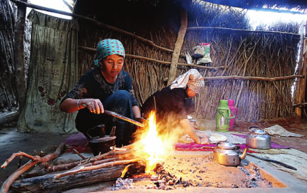 Women make a fire to cook in Daiyabuli township.