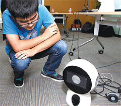 A technician interacts with Roby Mini. (Photo/China Daily)