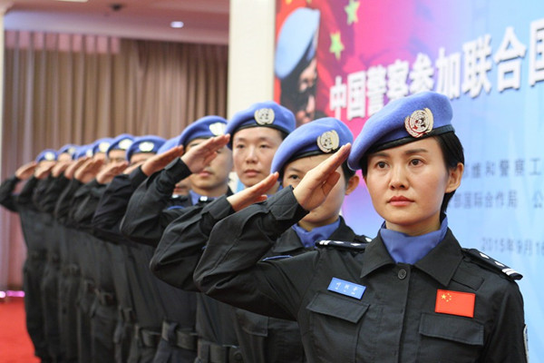 Ye Lixin (front) is among the 12 members of the 14th group of Chinese peacekeeping police officers being sent as part of the United Nations peacekeeping mission in Liberia. The group, which will depart on Thursday for Liberia, held a ceremony in Beijing on Wednesday. (Photo by Wang Zhuangfei/ China Daily)