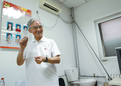 Jin Jiugao talks to visitors at his studio in Beijing's Wangjing area in July. He keeps a toilet there to explain to visitors how his water-saving device could be installed for toilets.  Photos by Guan Xin / China Daily