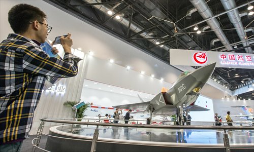A visitor takes a picture of a model of a fourth-generation fighter FC-31 being showcased at Aviation Expo China 2015, in Beijing on Wednesday. (Photo: Li Hao/GT)