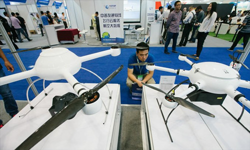 A visitor looks at two drones produced by Chinese company Space Geodata on September 16 at an aviation expo in Beijing. (Photo: Li Hao/GT)