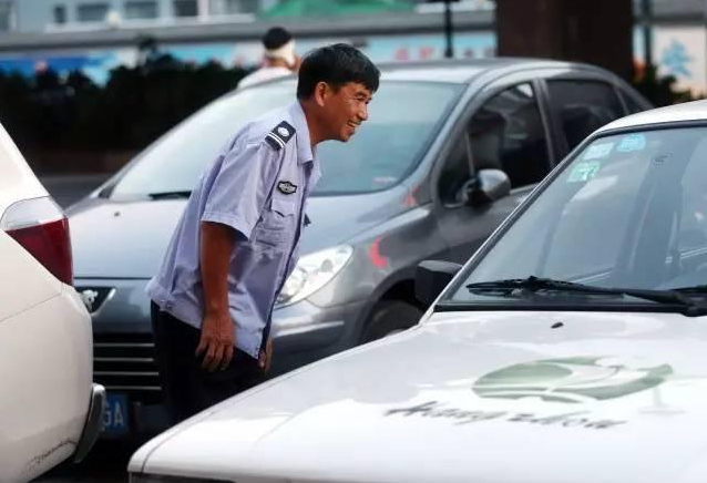 Chen instructs a car to park. (Photo/chinanews.com)