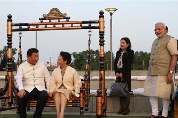 Chinese President Xi Jinping, left, and his wife Peng Liyuan play a swing during the visit in the western Indian city of Ahmedabad in Prime Minister Narendra Modi's home state of Gujarat on Sept 17, 2014.(Photo/huanqiu.com)