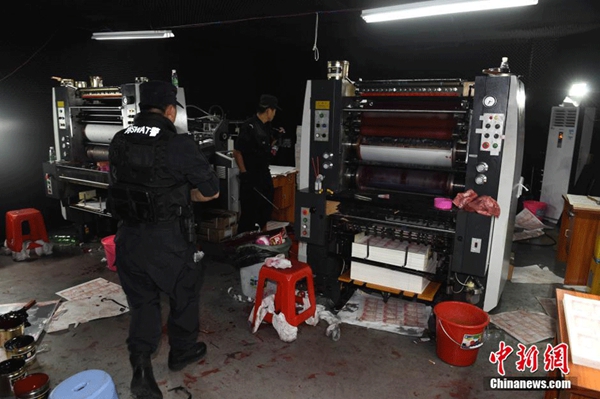 Police officers in Huizhou, in South China's Guangdong province, confiscate the machines used to print counterfeit 100-yuan banknotes, on Sept 24, 2015. (Photo/chinanews.com)