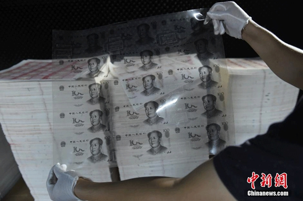 Police officers in Huizhou, in South China's Guangdong province, check out the rubber slab used for counterfeiting 100-yuan banknotes, on Sept 24, 2015. (Photo/chinanews.com)