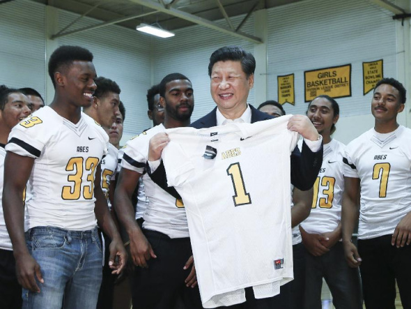 Chinese President Xi Jinping (C) is presented with a rugby shirt by students during his visit to the Lincoln High School in Tacoma of Washington State, the United States, Sept. 23, 2015. (Photo: Xinhua/Lan Hongguang)