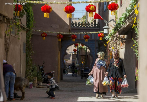 Women who have bought vegetables walk past their neighbor dealing with a sheep in Kashgar, northwest China's Xinjiang Uygur Autonomous Region, Sept. 23, 2015. Local Muslims prepared for the upcoming Corban Festival holiday, also known as Eid al-Adha or the feast of the sacrifice, in various ways. This year the Corban Festival falls on Sept. 24. (Photo: Xinhua/Jiang Wenyao)