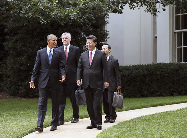President Xi Jinping walks on the grounds of the White House in Washington, DC, with US President Barack Obama after they gave a joint news conference on Friday. Lan Hongguang / Xinhua