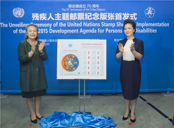 Peng Liyuan, right, the wife of Chinese President Xi Jinping, and Yoo Soon-taek, the wife of UN Secretary-General Ban Ki-moon, unveil at the United Nations in New York a custom-designed stamp honoring people with disabilities, Sept 27, 2015.(Photo/Xinhua)