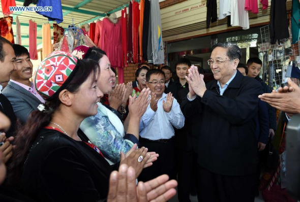 Yu Zhengsheng (R), chairman of the National Committee of the Chinese People's Political Consultative Conference (CPPCC), greets local residents of Uygur ethnic group while visiting a village in Elixku Township, Shache County of Kashgar, northwest China's Xinjiang Uygur Autonomous Region, Sept. 27, 2015. (Photo: Xinhua/Rao Aimin)
